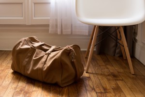 brown-duffel-bag-next-to-chair